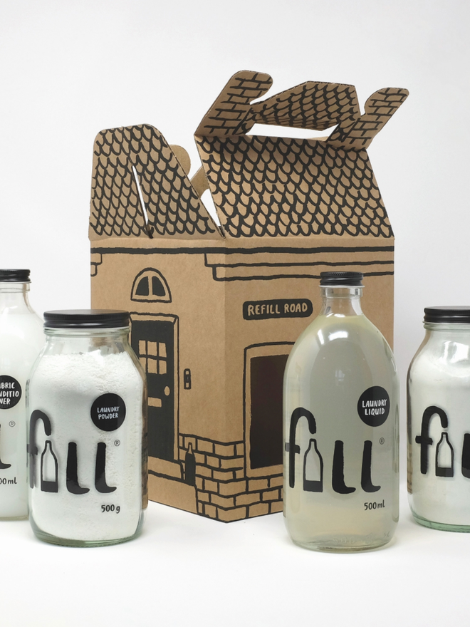 Loads of Laundry. A box shaped like a house with four jars of laundry products laid out nearby.