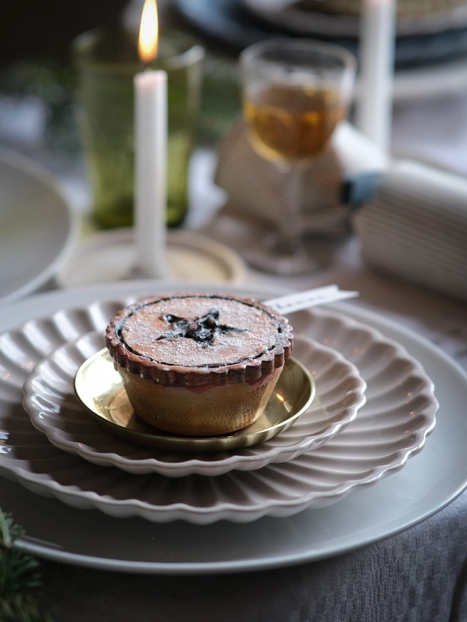 A festive handpainted wooden mince pie place setting with handwriten note to welcome your guests at the Christmas table