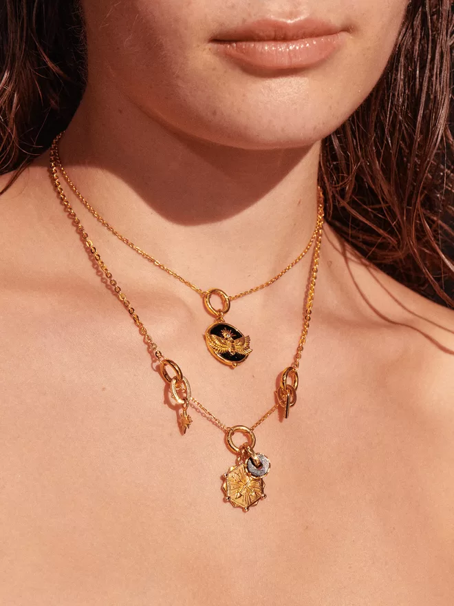 Woman wearing gold necklaces with charms and pendants