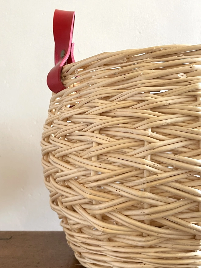 white round willow basket storage basketry one of a kind herringbone weave detail natural handcrafted red handles