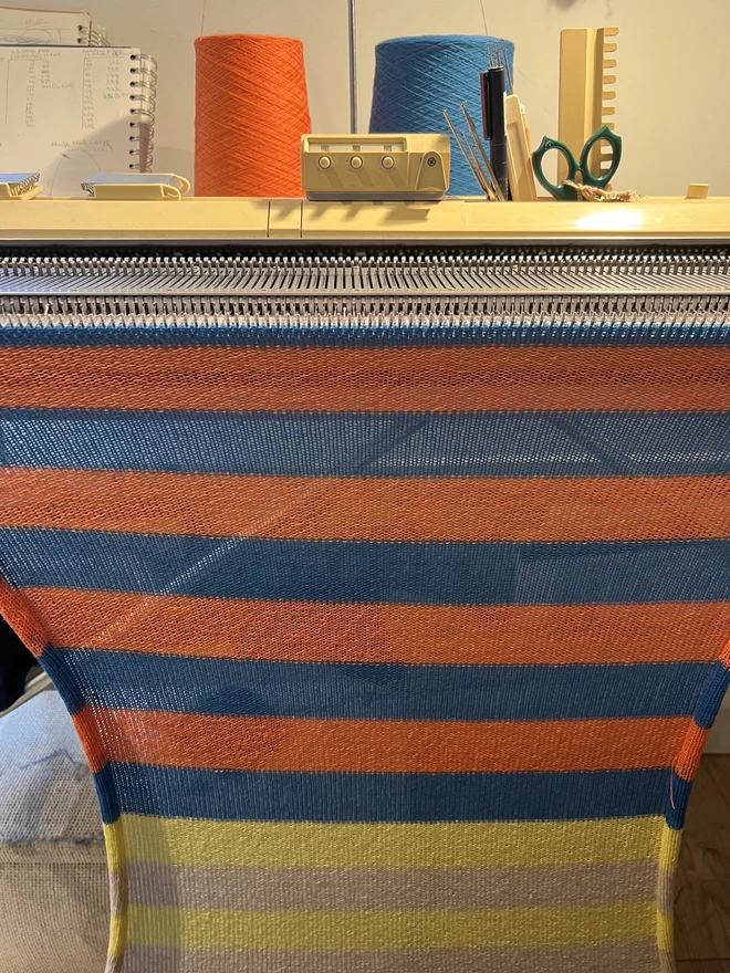 Blue Orange Yellow knitted snood shown on the knitting machine