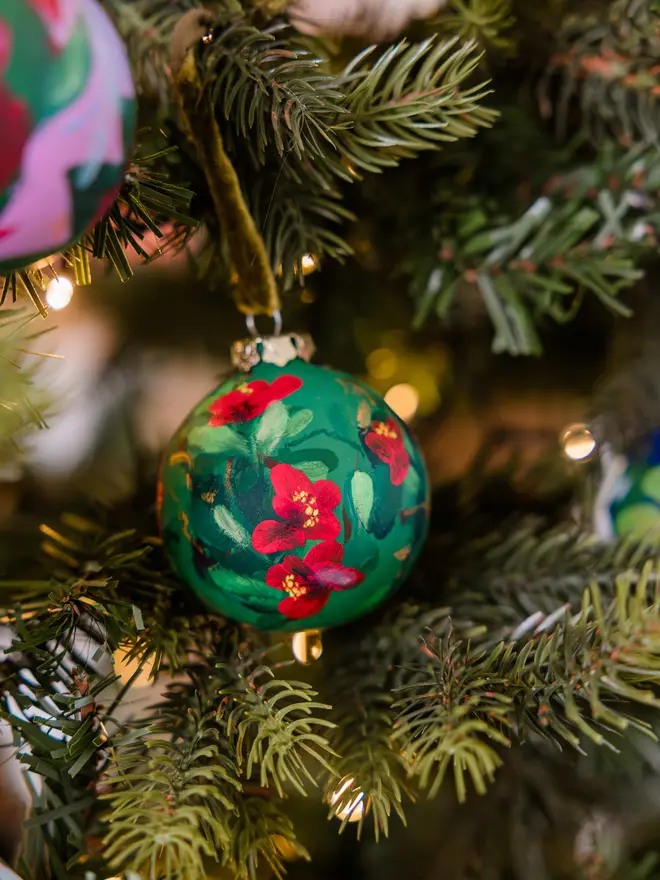 a set of six hand vibrant painted floral ceramic baubles all painted with an array of winter florals each finished with a luxurious velvet ribbon 