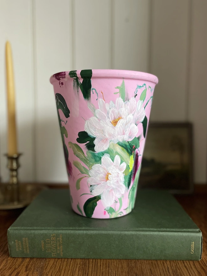 Unique hand-painted terracotta pot featuring pink peonies on a pale pink background