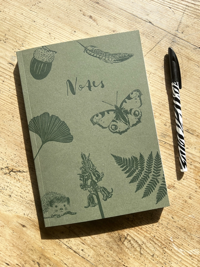 Front of the notebook showing greenery, insects and other woodland items.