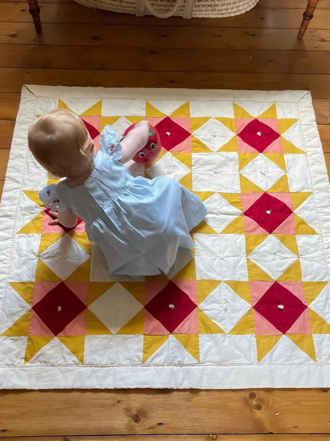 Warm Hearth Patchwork Quilt, with a child. 