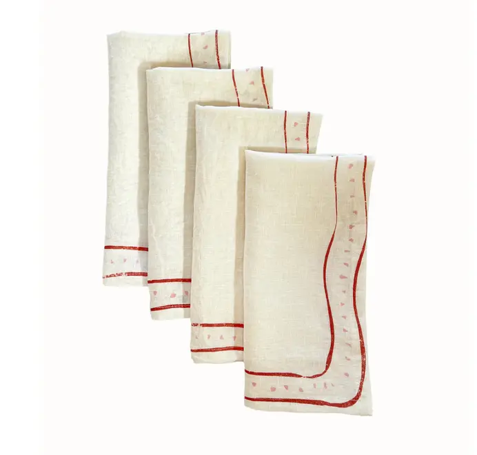 Grace Napkins (Set of 4). Light pink cloth napkin folded and staggered on a white background.