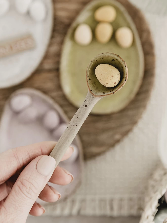 yellow ceramic spoon holding a yellow mini egg