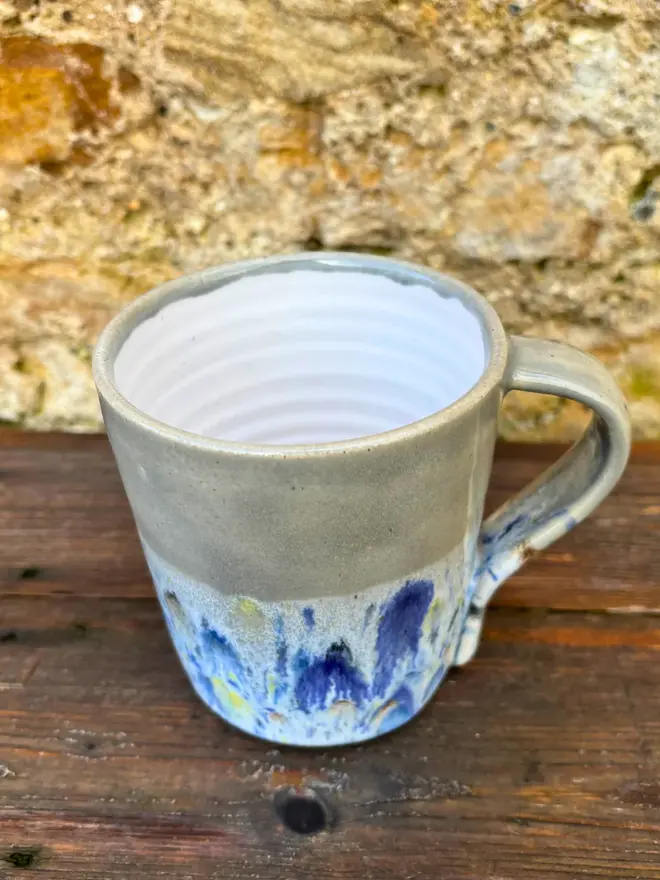Shoreline Standard Mug, a colourful mug placed on a wooden surface. 
