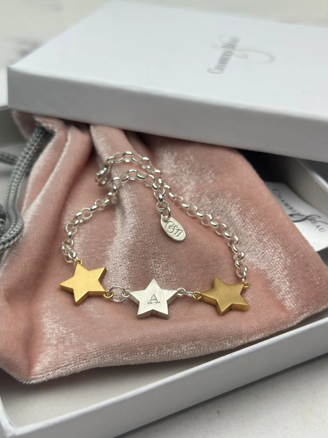 sterling silver belcher chain bracelet with two chunky gold star charms either side of one personalised sterling silver star charm. with gift box and pouch