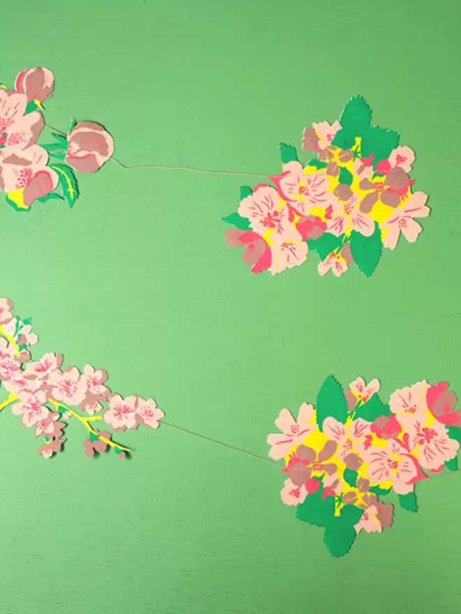 Blossom garland strung out on bright green background