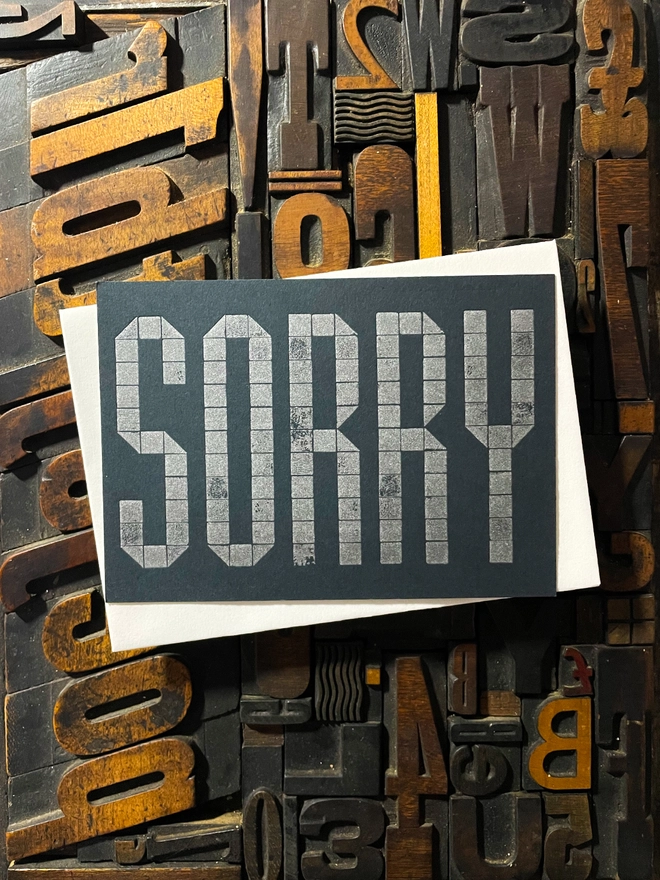 Sorry! A beautiful typographic letterpress postcard printed with metallic silver inks printed on rich thick  colourful card; ideal to send a sympathy note to a friend or loved one.