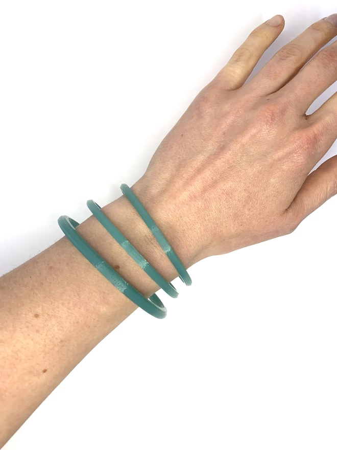 Small medium and large marine filament bangles made form 100% recycled fishing net being worn together 