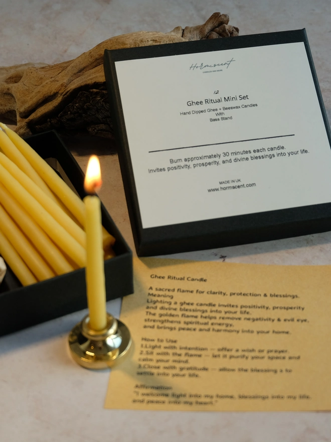 Hand-dipped ghee ritual candles in a gift box with a brass holder and a lit mini ghee candle for meditation, manifestation and spiritual rituals.