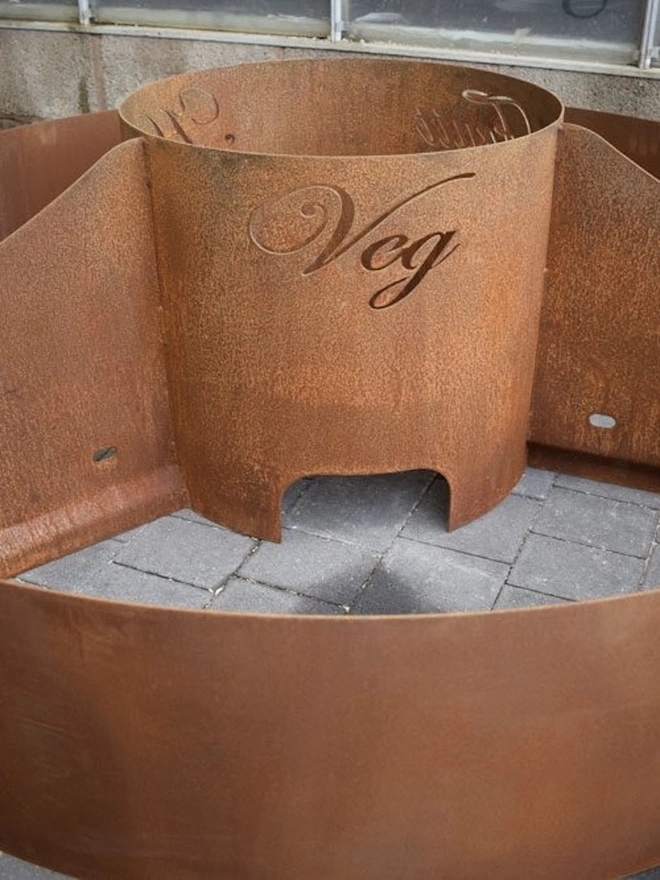 Circle Of Life Corten Vegetable Planter, in room with inscription on it. 