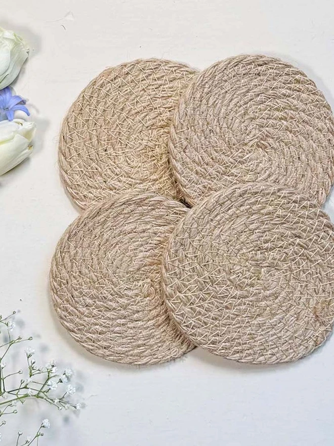 Seagrass coaster, shown on a light surface with purple flowers. 