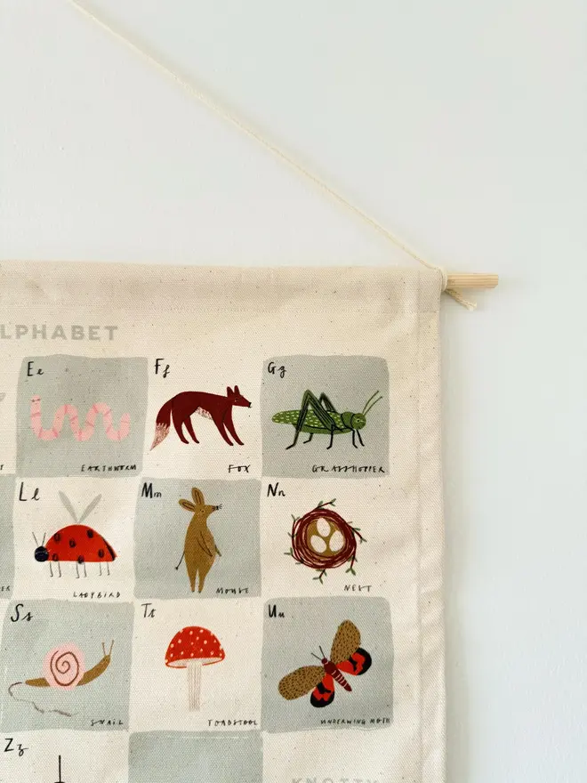 Woodland Alphabet Fabric Banner, hanging on a white wall. 