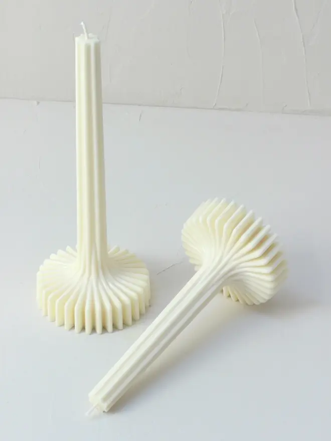 geometric aromatherapy soy candles (pack of 2). candles displayed on white surface, with one laid on its side.