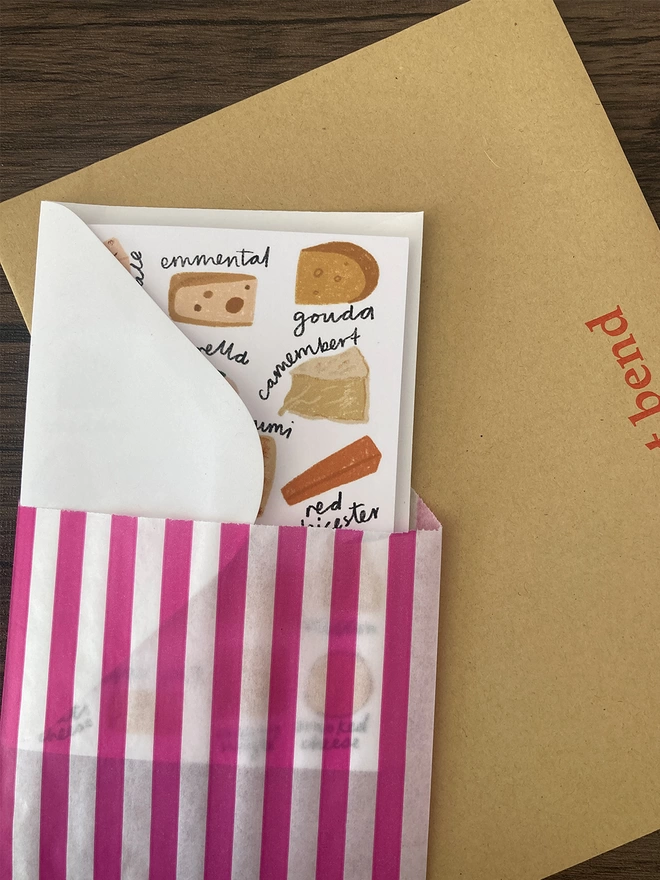 Cheese card packed with a white envelope inside a paper bag