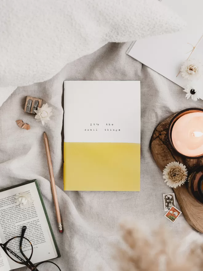 yellow and white gratitude journal with 'it's the small things' typed on the cover