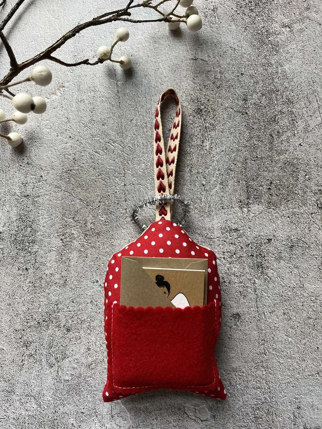 the back of a Christmas tree angel with a red felt pocket with a little matching angel card and envelope peeking out