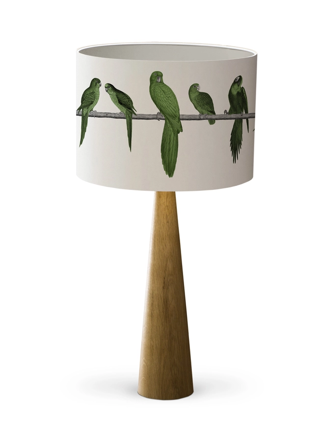 A colourful lampshade featuring a lively group of green parrots in a tropical jungle-inspired design, bringing a playful touch to home interiors.