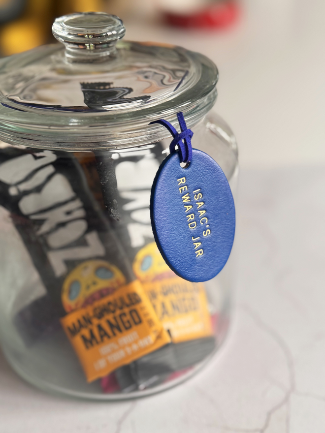 blue leather reward jar label on a glass jar of sweets.
