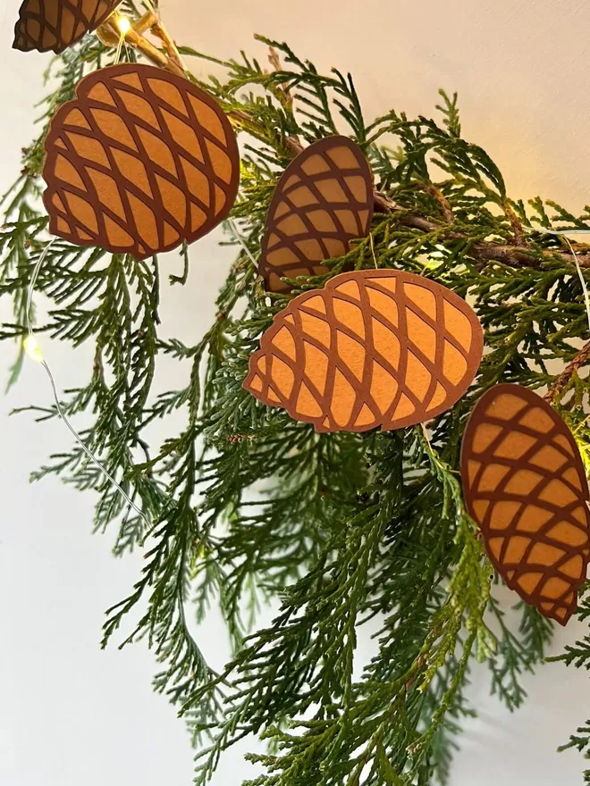 Closeup of Pinecone Paper Decoration against winter greenery