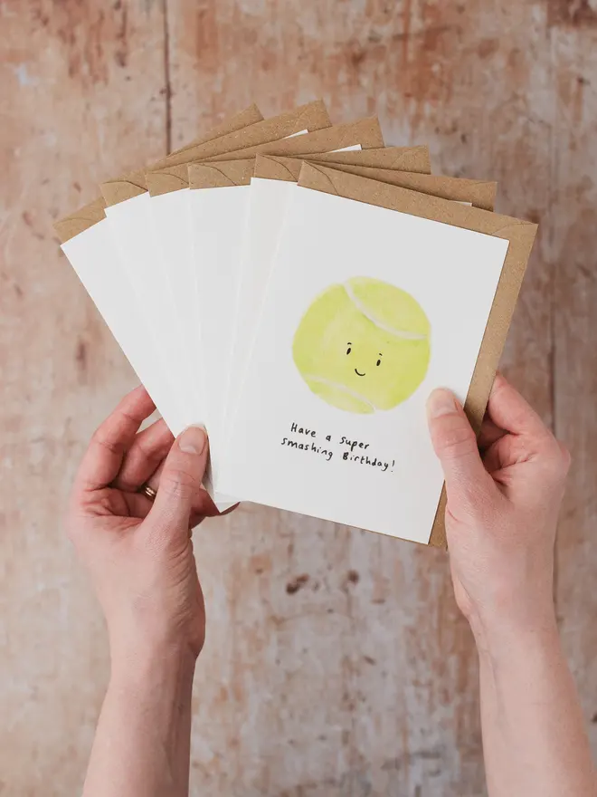 Hand holding 6 Sport Ball Birthday Cards featuring a Tennis Ball Card