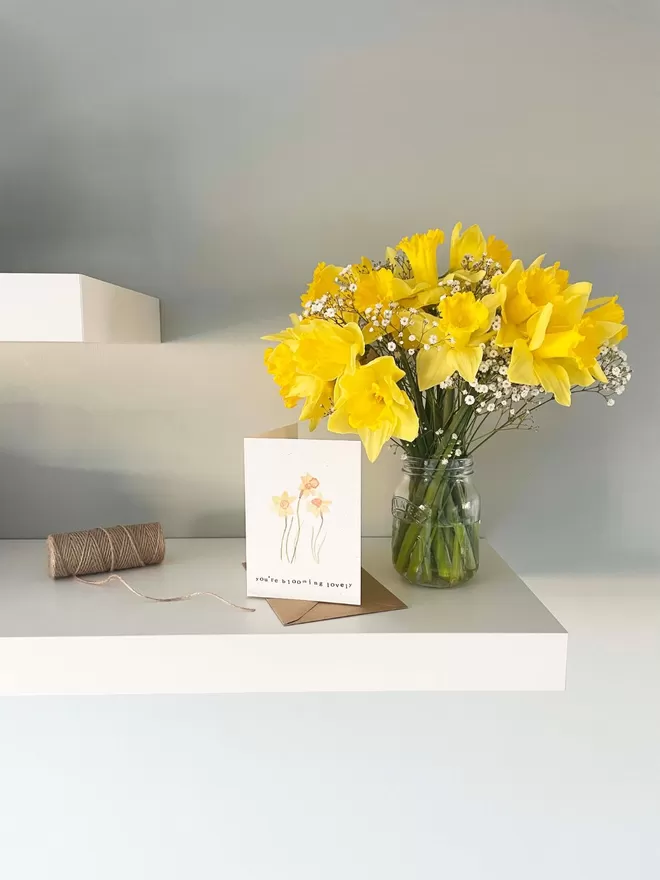 'You're Blooming Lovely' Card being displayed on a shelf with daffodils in a vase