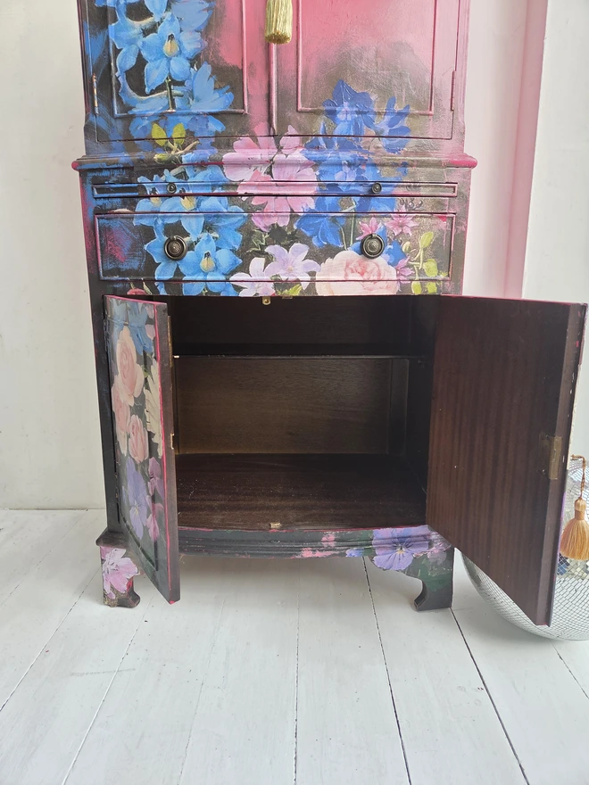 Interior of painted vintage wooden cabinet with pink, blue and floral decoration