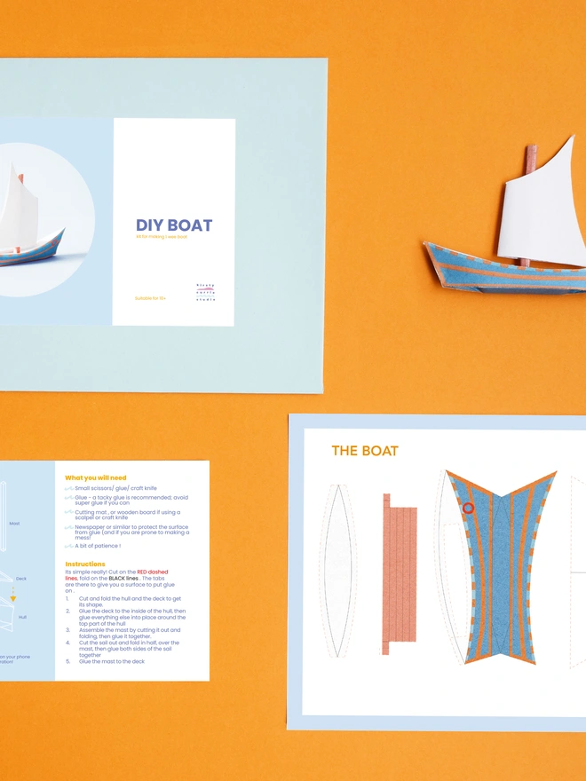 A photo of the elements of the DIY kits laid flat including - instructions, cut out sheet, a bothy made of a paper, an envelope with a label saying it is a DIY kit. 