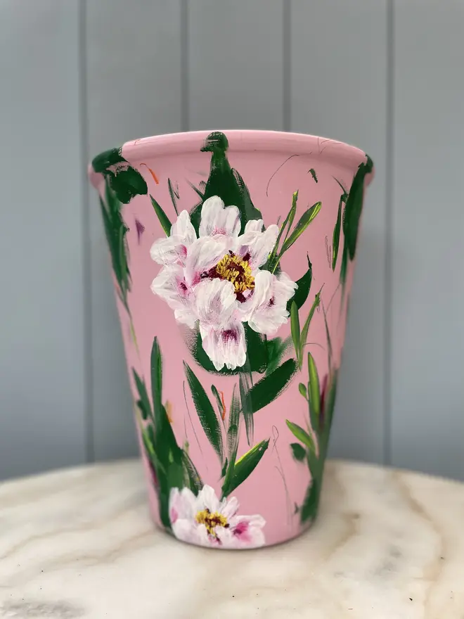 Unique hand-painted terracotta pot featuring pink tree peony on a pale pink background