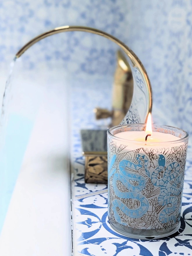 enchanted, amber & tonka bean candle in a reusable glass in a bathroom setting