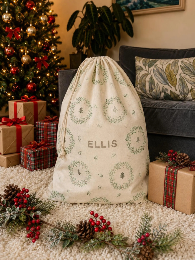 personalised drawstring christmas sack. a drawstring bag with printed christmas motifs and a personalised name.