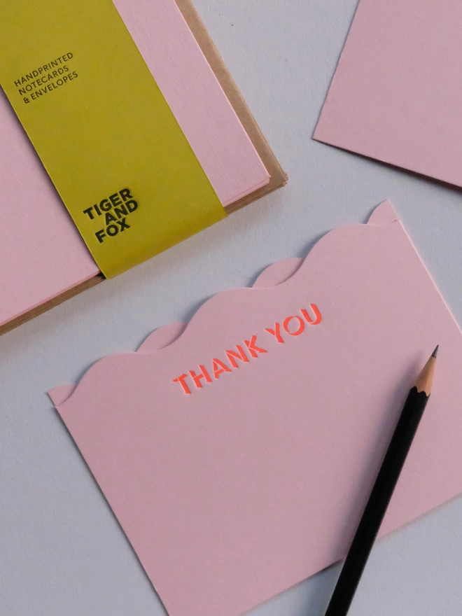 Neon 'Thank you' lettering on pink notecard. Set includes a green bellyband. 