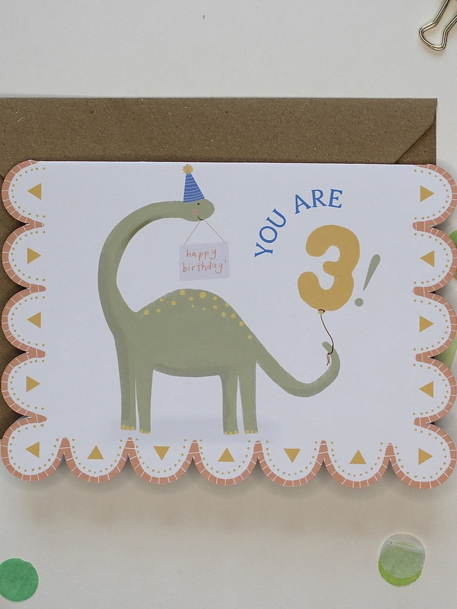 illustrated dinosaur birthday card. scallop edged card illustrated with stegosaurus.