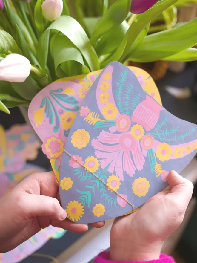 Lilac and pink shapes in front of tulip leaves