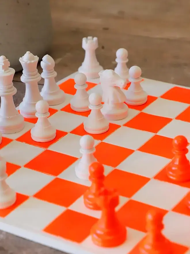 Handmade Jesmonite Chess Board, a handmade colourful chess board sitting on a wooden surface. 