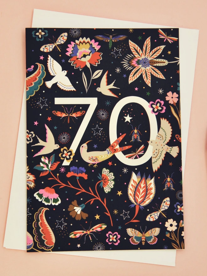 black birthday card with floral and bird designs, with off white "70" 