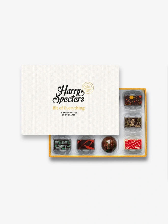 A box of 12 chocolate partially covered by a Harry Specters lid