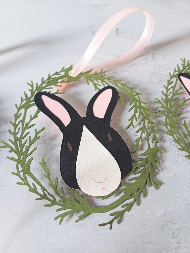 Black Rabbit Paper Decoration. Rabbit has pale pink ears, white nose patch and dark brown eyes