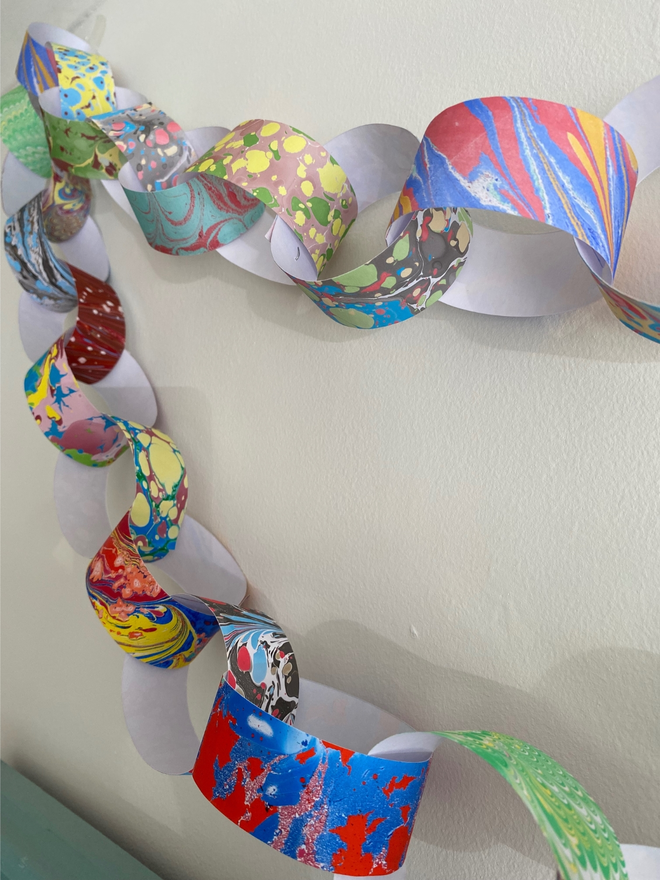 hand marbled multi colour paper chain hanging on wall