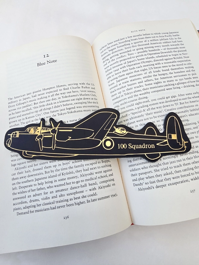 black and gold embossed leather Avro Lancaster bomber plane bookmark on a book personalised with the one hundred squadron