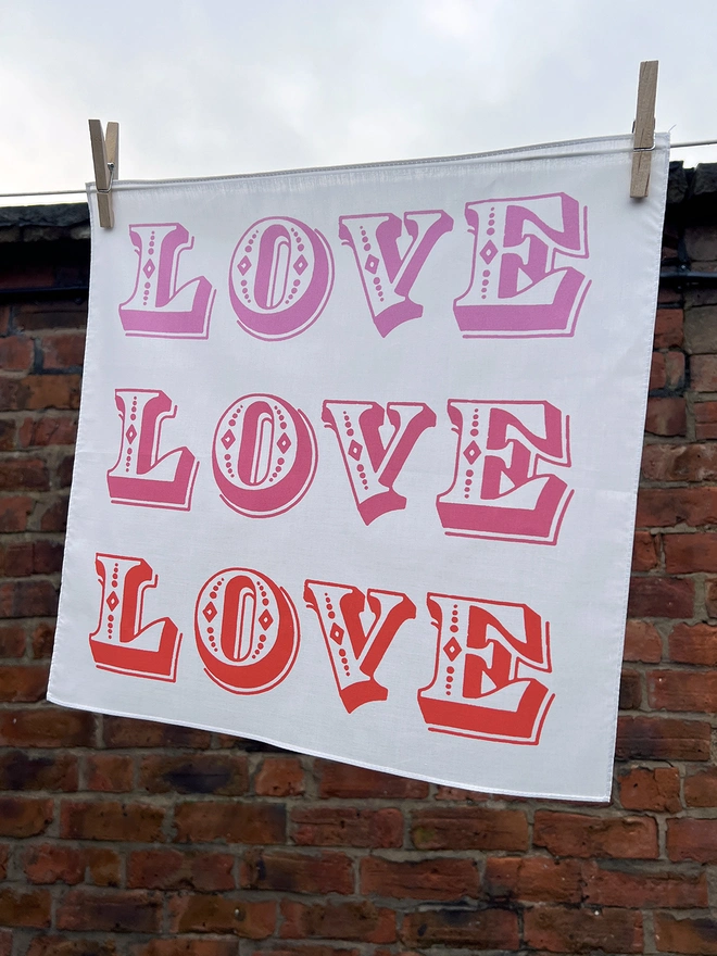 A Mr.PS Love Love Love Handkerchief hanging outside on a washing line