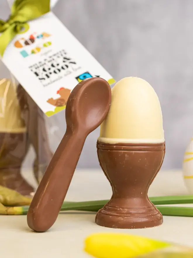 Chocolate egg and spoon on a table with daffodills