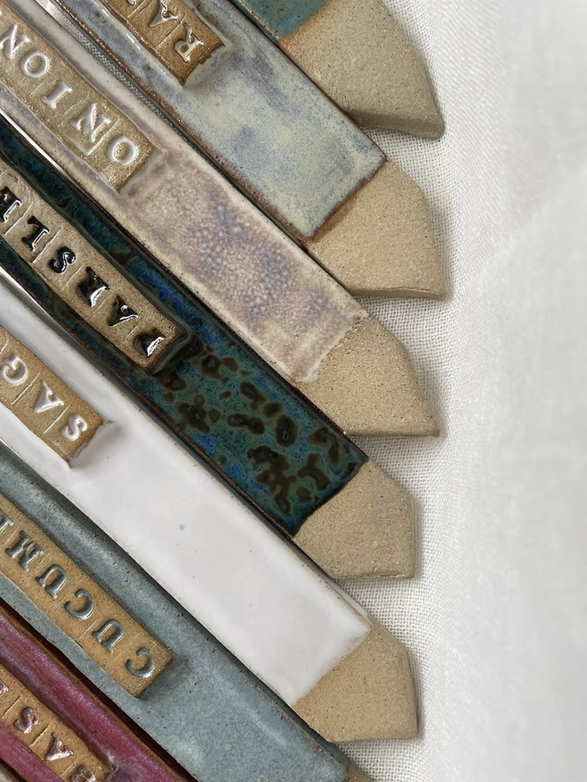 Stoneware Garden Labels , a group of colourful stoneware garden labels on a white surface. 