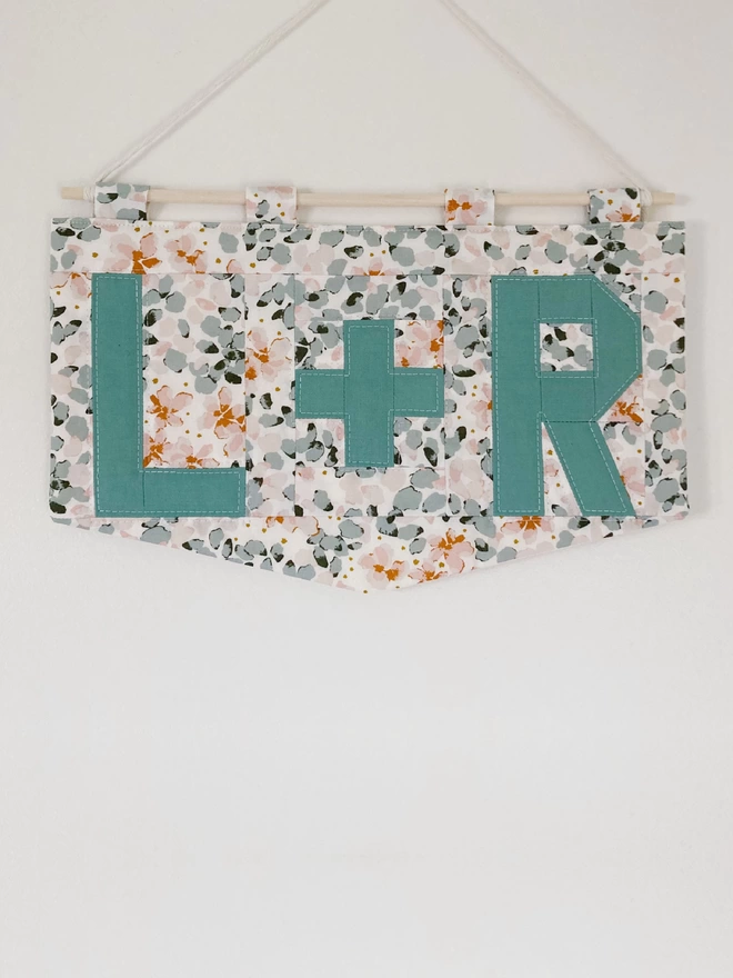 Cooper and Fred personalised double letter wallhanging using pale floral patterns and light blue lettering.