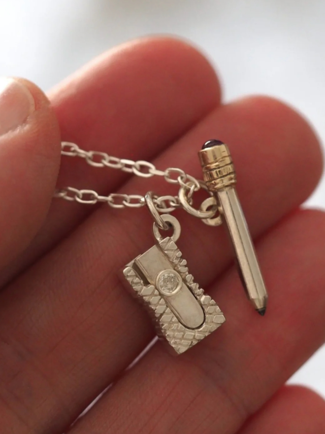 Pencil & Sharpener Necklace. A silver pencil and sharpener necklace.