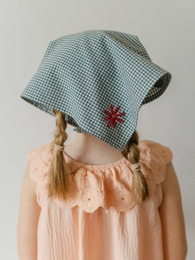 girl wearing a blue gingham bandana on her head