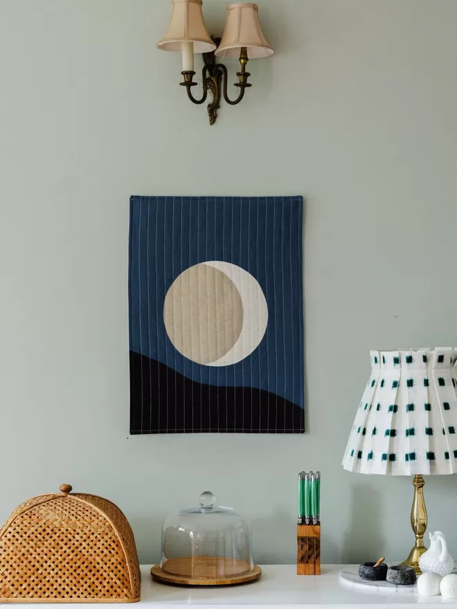Midnight Quilt Hanging On Wall Above Table